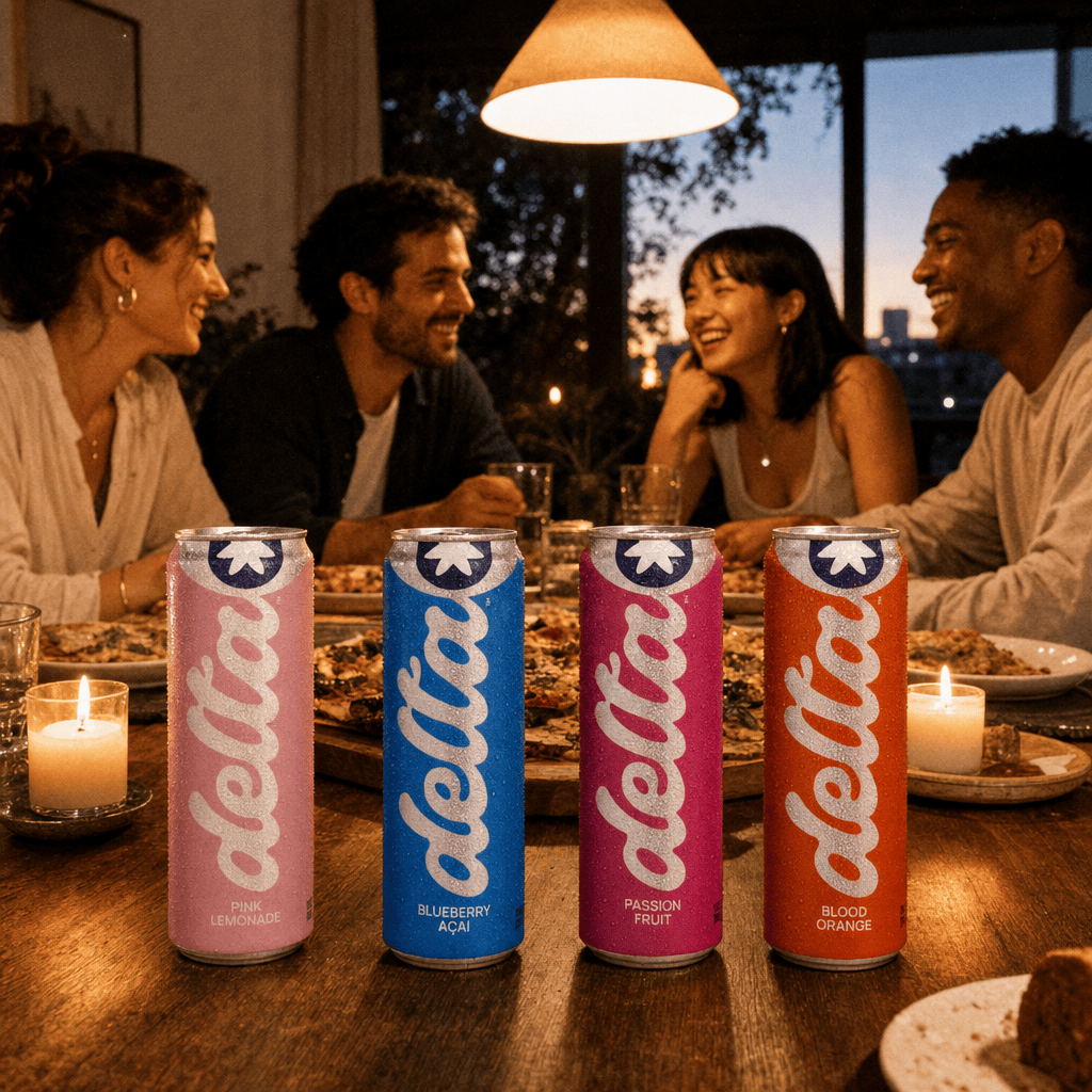 A four-person dinner-party table mid-meal, candles lit, all four Moderate flavors at place settings, guests in conversation.